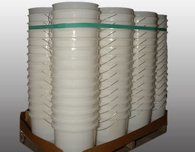 Picture of white buckets on a pallet secured with a rubber band.