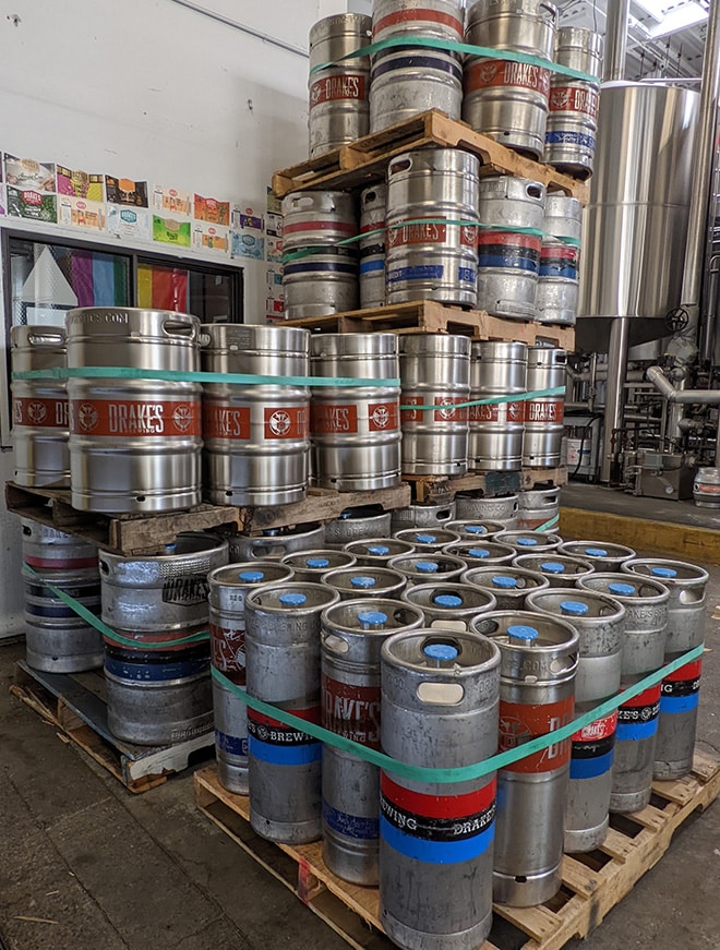 Pallets of empty kegs, secured by large green rubber bands